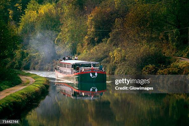 side view of a luxury barge moving upstream, france - barge stock-fotos und bilder