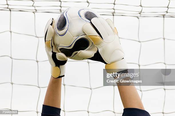 close-up of a goalie's hands holding a soccer ball - goalkeeper hand stock pictures, royalty-free photos & images