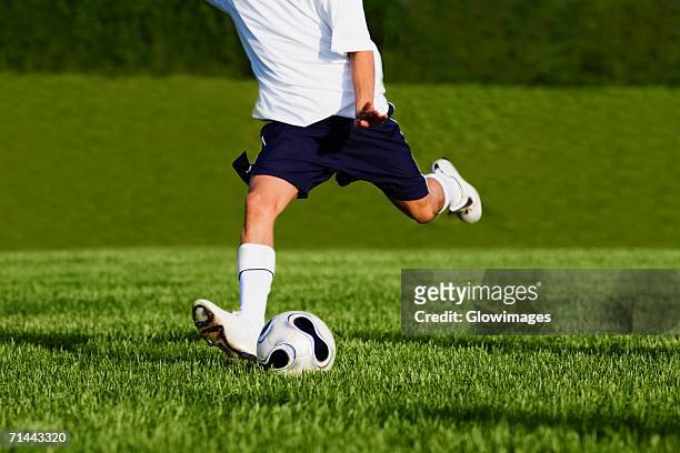 low section view of a soccer player playing soccer - studded stock-fotos und bilder