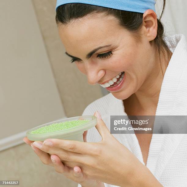 close-up of a young woman looking at a dish of bath crystals - soap dish stock pictures, royalty-free photos & images