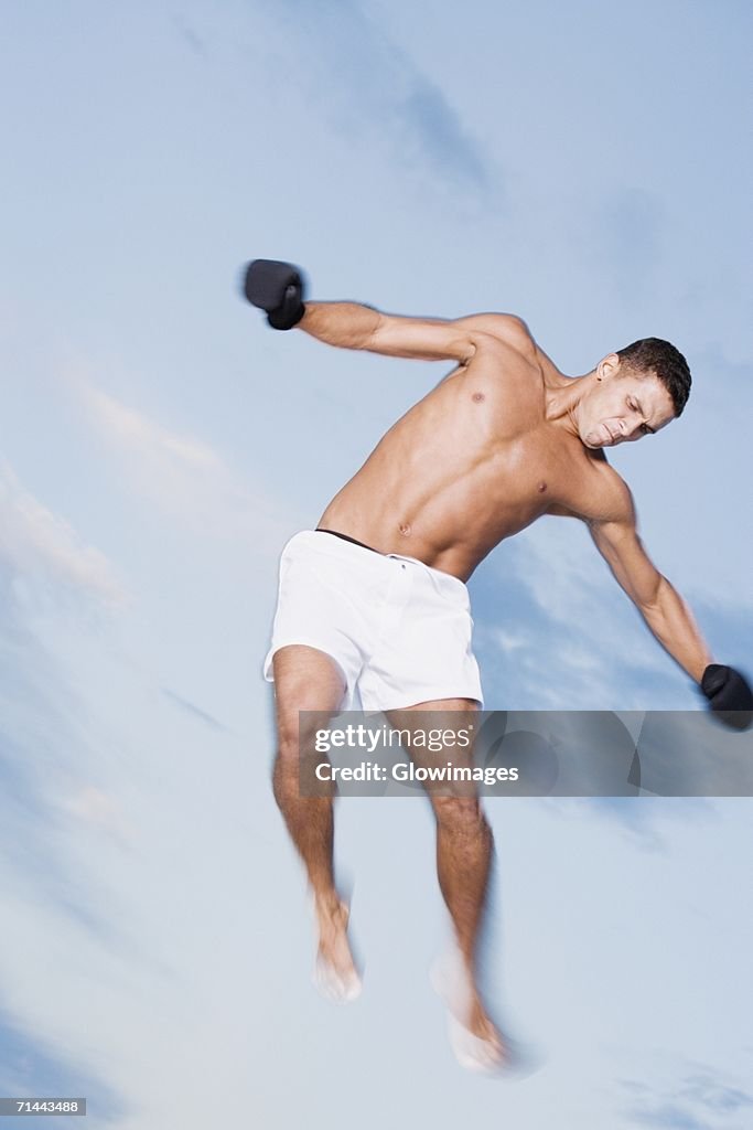 Low angle view of a young man jumping with his arms outstretched