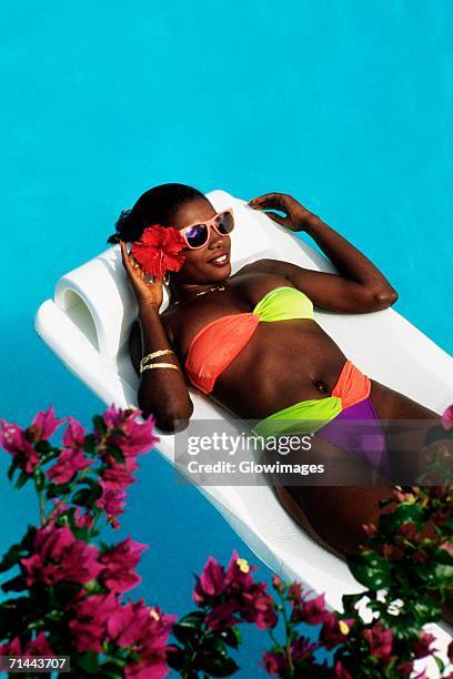 an african-american woman is floating on an inflatable mattress in a swimming pool, destiny villa, jamaica - jamaica people stock pictures, royalty-free photos & images