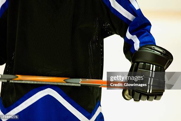 mid section view of an ice hockey player holding an ice hockey stick - ice hockey glove stock-fotos und bilder