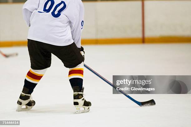 rear view of an ice hockey player playing ice hockey - ice hockey player back turned stock pictures, royalty-free photos & images