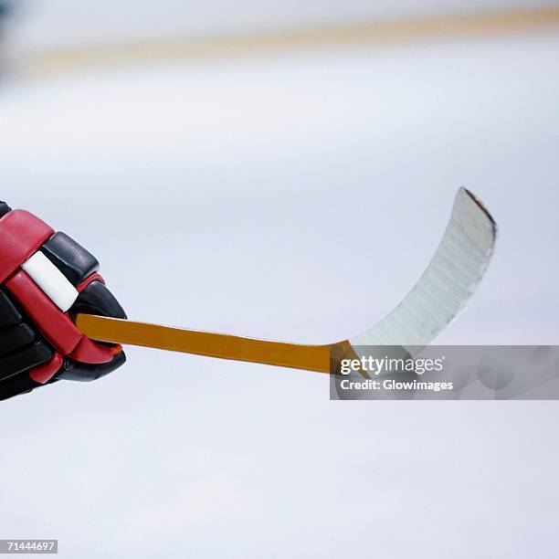 close-up of an ice hockey player's hand holding an ice hockey stick - hockey stick close up stock pictures, royalty-free photos & images