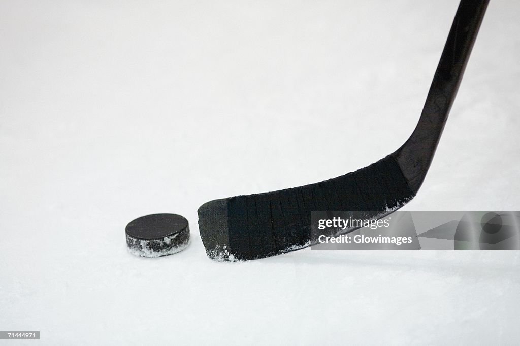 Close-up of an ice hockey stick with a hockey puck