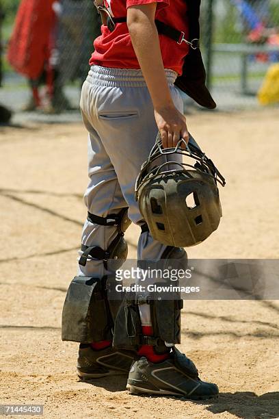 low section view of a baseball catcher holding a helmet - shinguard fotografías e imágenes de stock