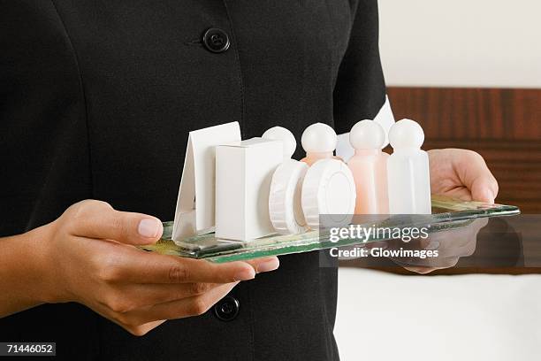 mid section view of a woman holding a serving tray - amenities hotel stockfoto's en -beelden