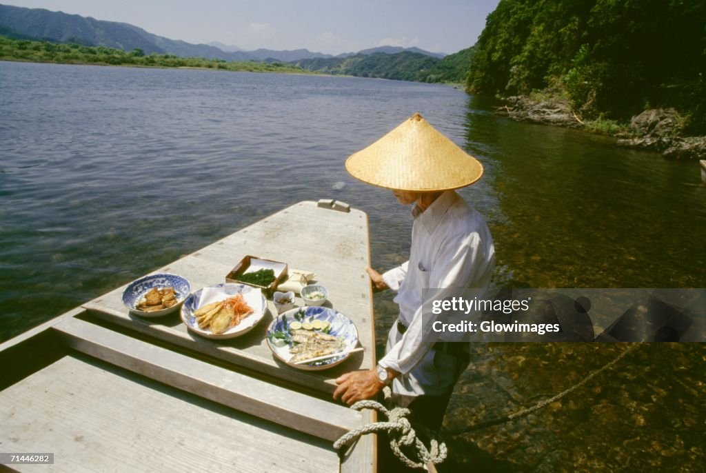 Mature man standing near a boat, Shimanto River, Kochi, Shikoku, Japan