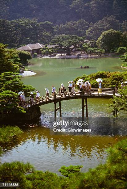 group of people walking on a bridge, ritsurin garden, takamatsu, shikoku, japan - takamatsu bildbanksfoton och bilder
