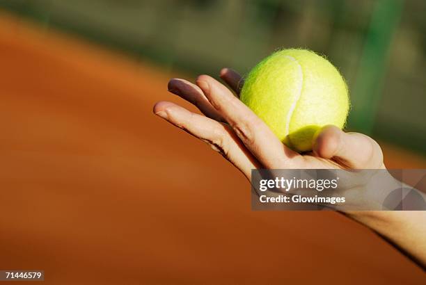 close-up of a person's hand holding a tennis ball - tennisbal stockfoto's en -beelden