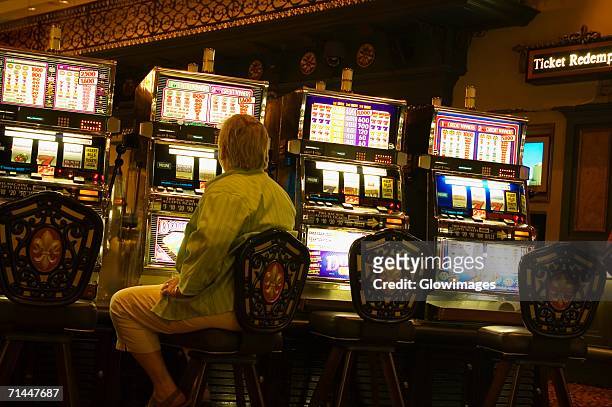 rear view of a man sitting at a slot machine, new orleans, louisiana, usa - gambling addiction stock-fotos und bilder