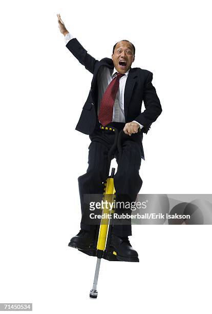 portrait of a businessman on a pogo stick - pogo stick stock pictures, royalty-free photos & images
