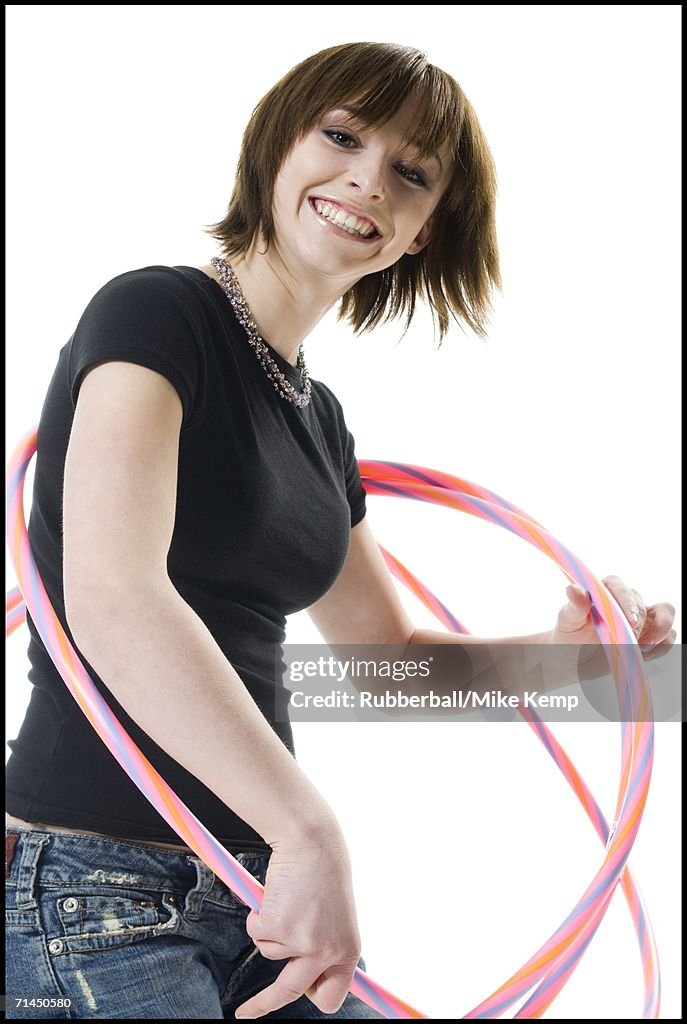 Portrait of a teenage girl playing with hula hoops