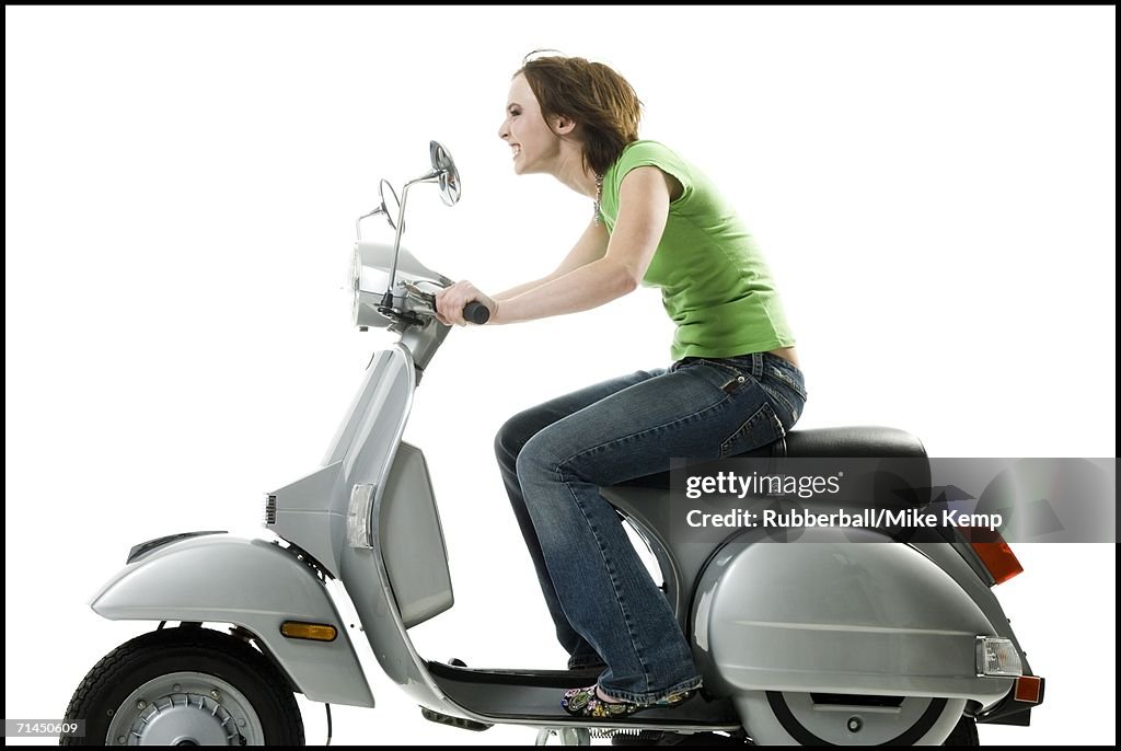 Profile of a teenage girl riding a scooter