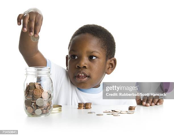 close-up of a boy collecting coins in a jar - coin collection stock pictures, royalty-free photos & images