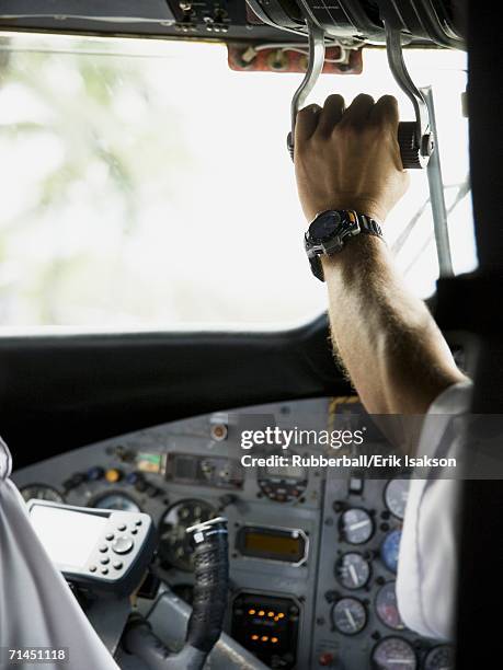 Rear View Of A Pilot Operating The Control Panel In An Airplane High ...