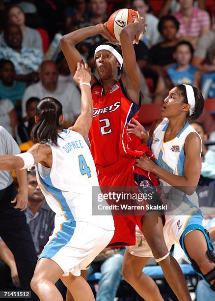 Michelle Snow of the Houston Comets looks to pass the ball against Candice Dupree and Stacey Lovelace-Tolbert of the Chicago Sky on July 14, 2006 at...