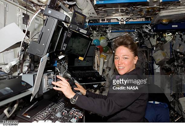 Mission specialist Lisa M. Nowak works at the Mobile Service System and Canadarm2 controls in the Destiny laboratory of the International Space...