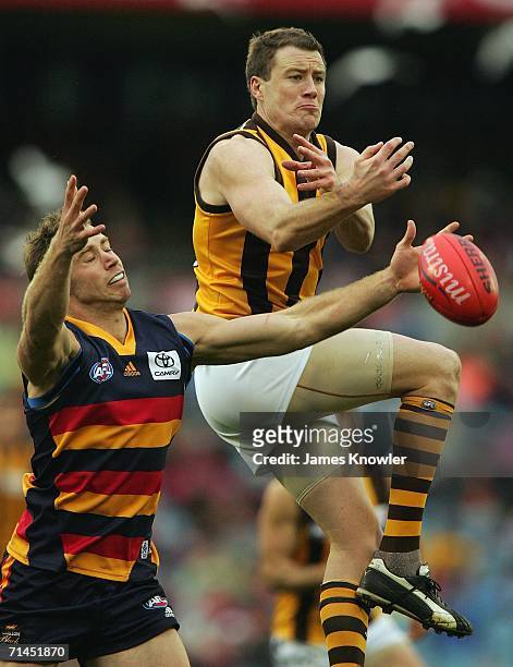 John Barker of the Hawk trys to mark the ball over Ben Rutten of the Crows kick for goal during the round 15 AFL match between the Adelaide Crows and...