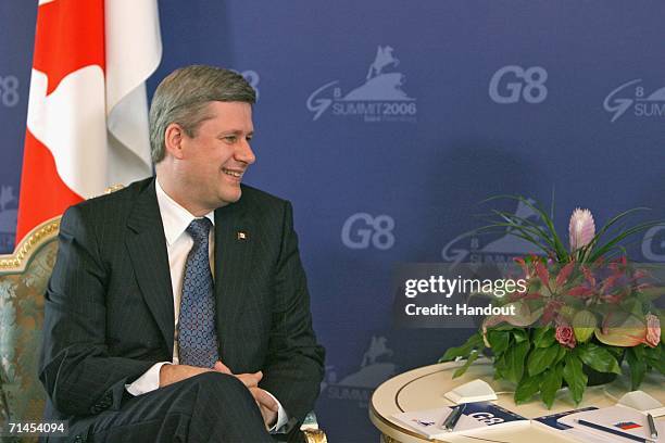 In this handout photo, Canadian Prime Minister Stephen Harper meets Russian President Vladimir Putin at the International Media Centre on July 15,...