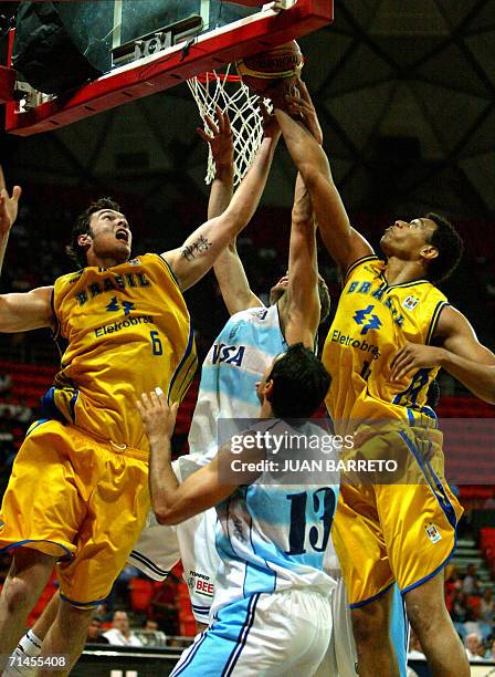 Nicolas Gianella de Argentina toma un rebote junto a los jugadores Murilo Becker y Marcelinho Huertas de Brasil, durante un partido del Campeonato...