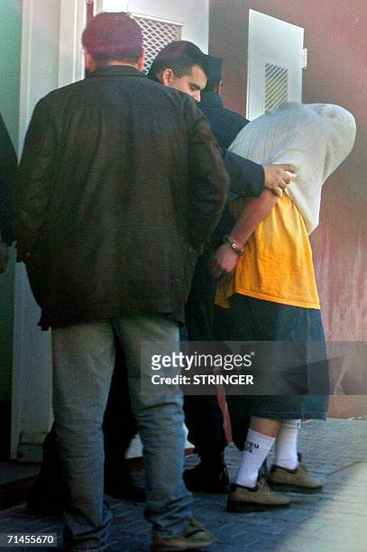 Buenos Aires, ARGENTINA: Funcionarios policiales trasladan para tomarle declaracion el 15 de julio de 2006, al joven que la vispera fue detenido y...