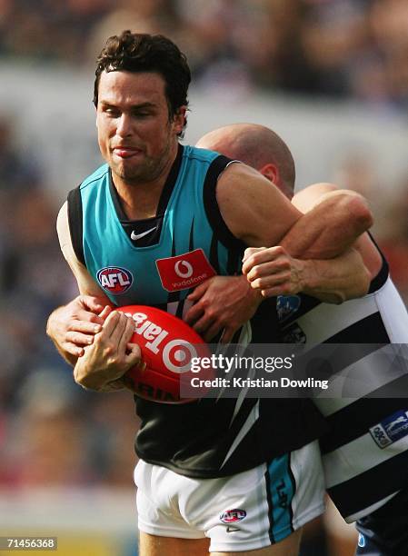 Nathan Lonie of the Power is tackled by Paul Chapman of the Cats during the round 15 AFL match between the Geelong Cats and the Port Adelaide Power...