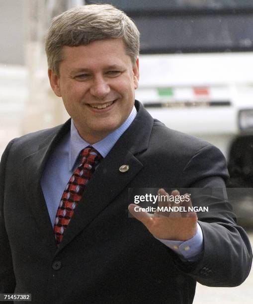 Canadian Prime Minister Stephen Harper waves as he arrives for a meeting between G8 Leaders and Junior 8 Student Leaders 16 July 2006 at the Marble...