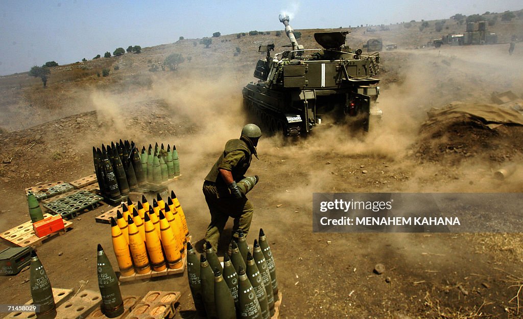 Israeli soldiers reload a mobile artille