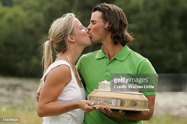 Johan Edfors of Sweden holds the trophy and kisses his girlfriend Cecilia following his victory after the final round of The Barclays Scottish Open...