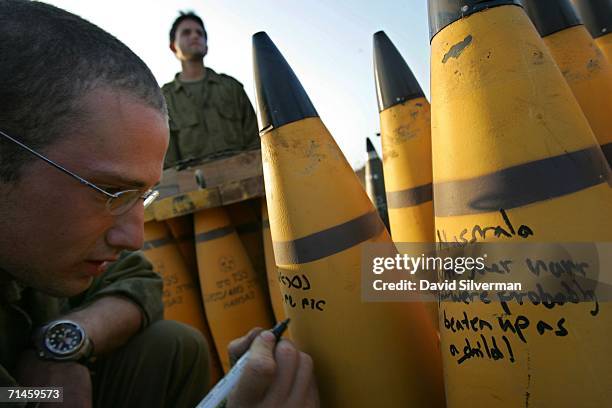 Israeli soldiers write messages to Hezbollah leader Sheikh Hassan Nasrallah on 155mm artillery shells before firing them at Hezbollah targets in...