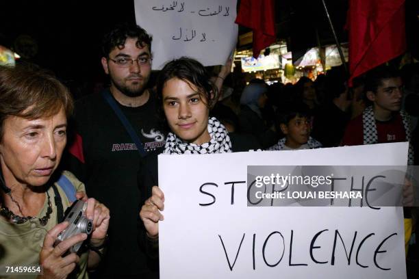 Palestinians hold banners reading "No to violence, no to fear, no to humiliation" and calling for an end to the violence in Lebanon during an...