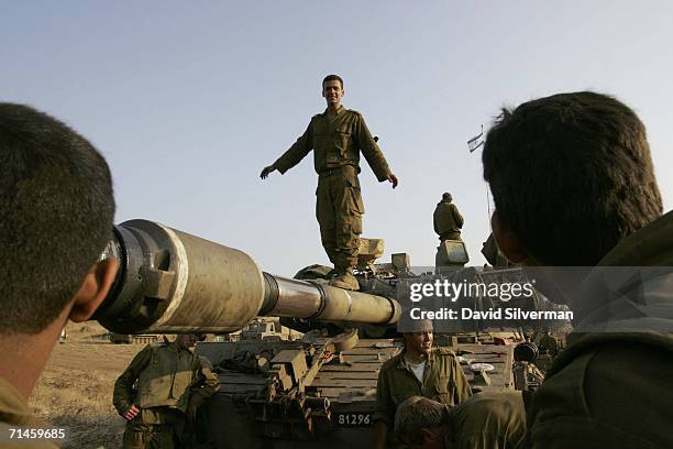 An Israeli soldier walks along the barrel of a 155mm artillery piece during a lull in firing against Hezbollah targets in South Lebanon July 16, 2006...