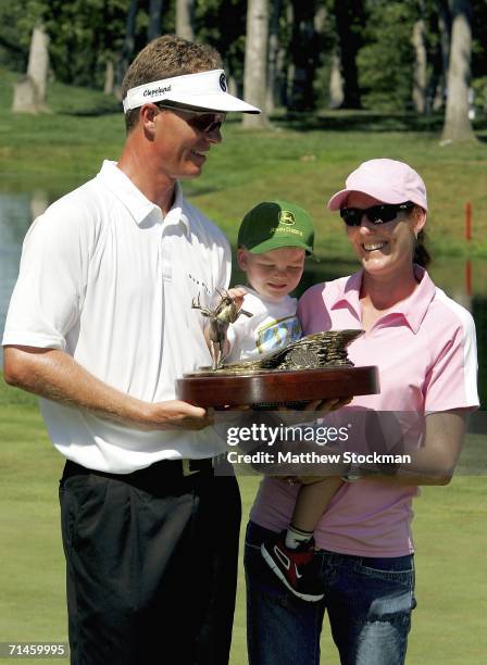 John Senden of Australia holds his trophy as he poses with his wife Jackie and son Jacob after the final round of the John Deere Classic July 16,...