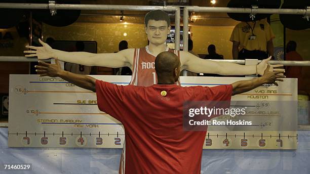 Fan compares his arm span to that of Yao Ming of the Houston Rockets during the Rhythm N' Rims Tour on July 16, 2006 at the Convention Center in...