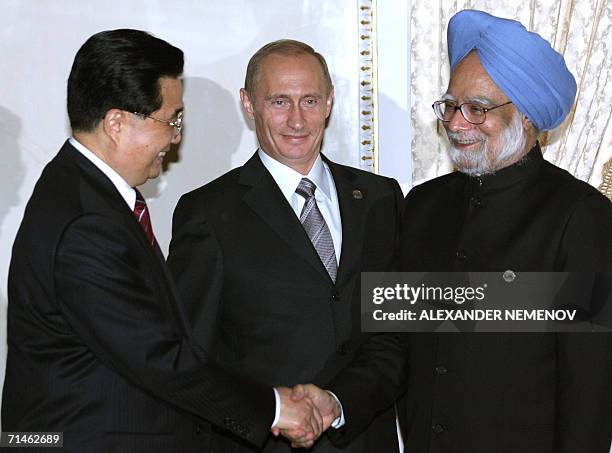 St Petersburg, RUSSIAN FEDERATION: Chinese President Hu Jintao shakes hands with Indian Mahnmohan Singh as Russian President Vladinir Putin looks on...