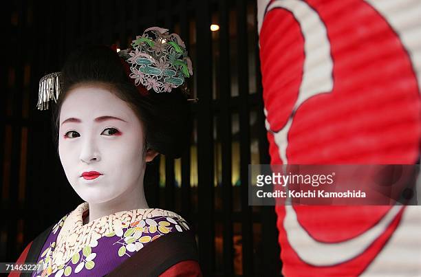 Maiko poses for a picture during the Gion Festival July 17, 2006 in Kyoto, Japan. The traditional festival started in 869 AD after a plague spread...