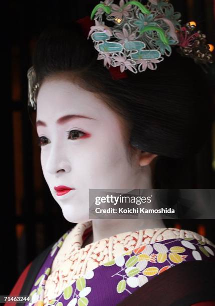Maiko poses for a picture during the Gion Festival July 17, 2006 in Kyoto, Japan. The traditional festival started in 869 AD after a plague spread...
