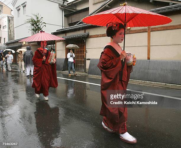 Maiko walks with an umbrella during the Gion Festival July 17, 2006 in Kyoto, Japan. The traditional festival started in 869 AD after a plague spread...