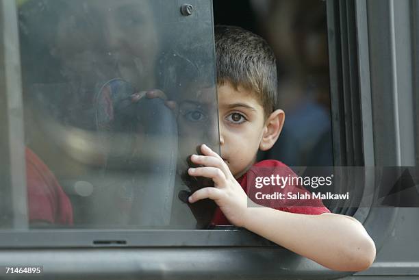 Lebanese child looks out of the window of a bus as he waits with his family to cross into Syria July 17, 2006 at the checkpoint of al Masnaa,...