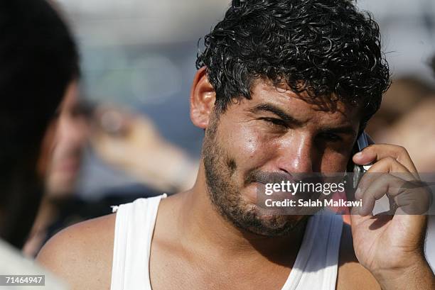 Lebanese man receives the news of the death of his brother on a cell phone as he arrives to cross into Syria July 17, 2006 at the checkpoint of al...