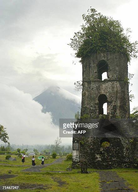 The belfry of 18th century Cagsawa church stands buried under volcanic ash and rocks in Albay province, 17 July 2006 while in the background cloud...