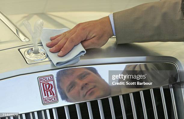 Man cleans the exterior of the United Kingdom premiere of the Rolls-Royce 101EX concept car as it sits on display at the British International Motor...