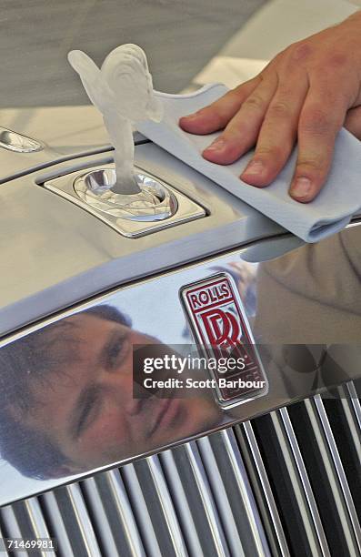 Man cleans the exterior of the United Kingdom premiere of the Rolls-Royce 101EX concept car as it sits on display at the British International Motor...