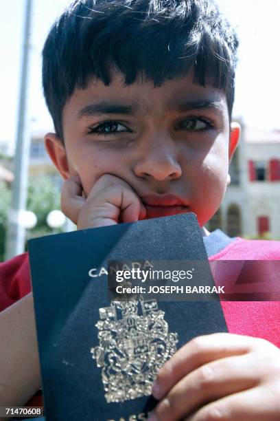 Lebanese-Canadian boy cries as he holds his Canadian passport in front of al-Qaderi hotel in Zahle city in the Bekaa valley as Canadian nationals get...
