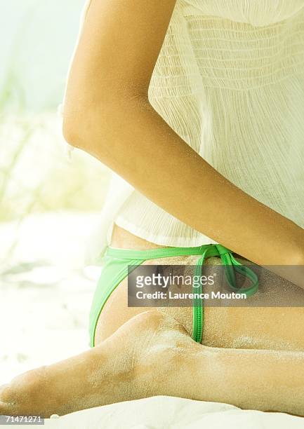 woman sitting in sand, close-up of mid-section - monokini stock pictures, royalty-free photos & images
