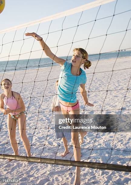preteen girls playing beach volleyball - volear fotografías e imágenes de stock