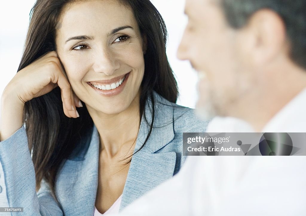 Businesswoman smiling at colleague, close-up