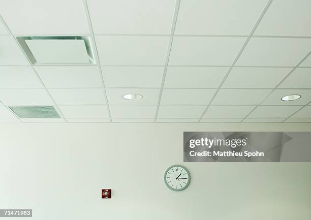clock on wall in office space - ceiling stock-fotos und bilder
